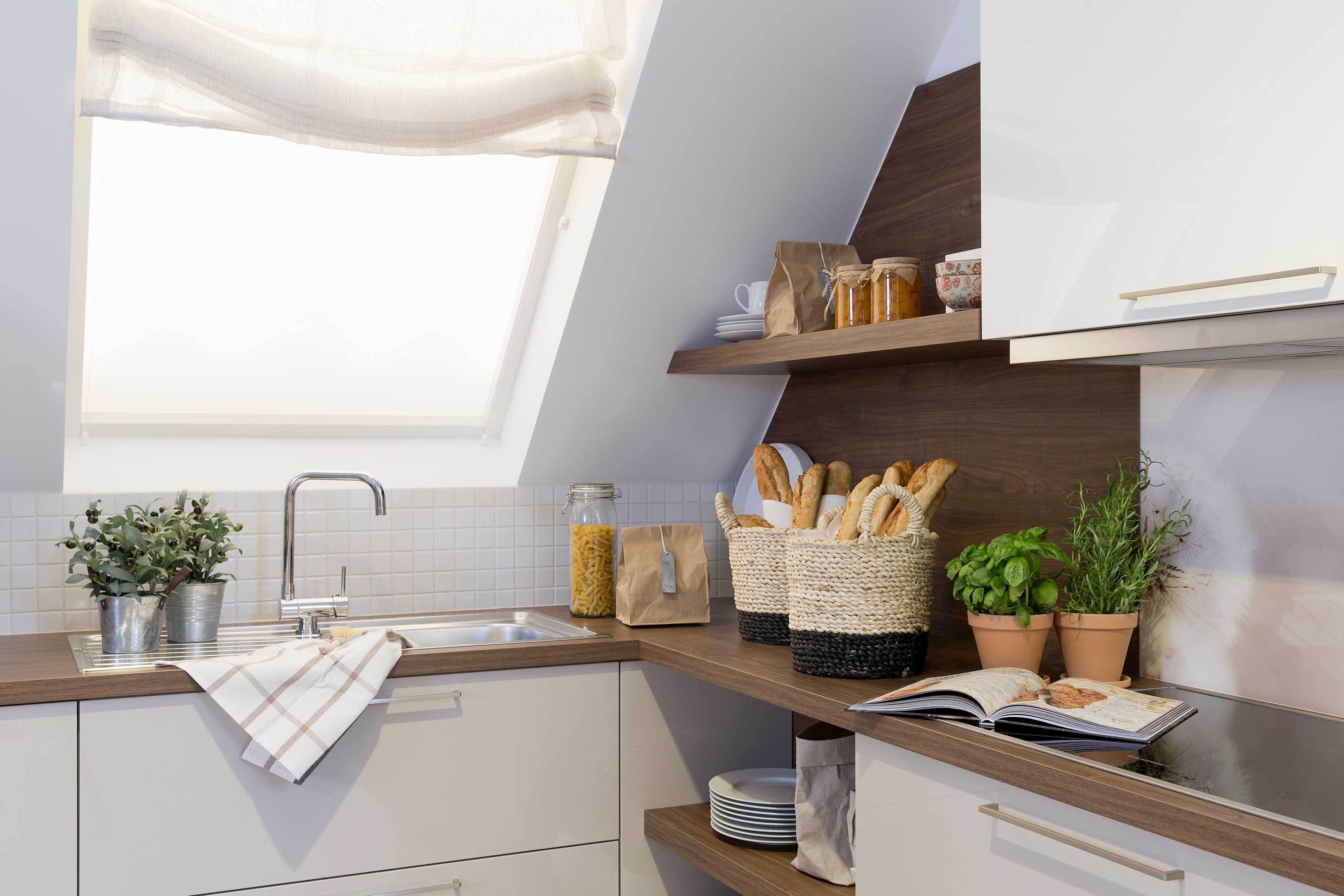 Weiße_offene_Hochglanzküche_von_Häcker_mit_Einbauofen_und_Dachschräge