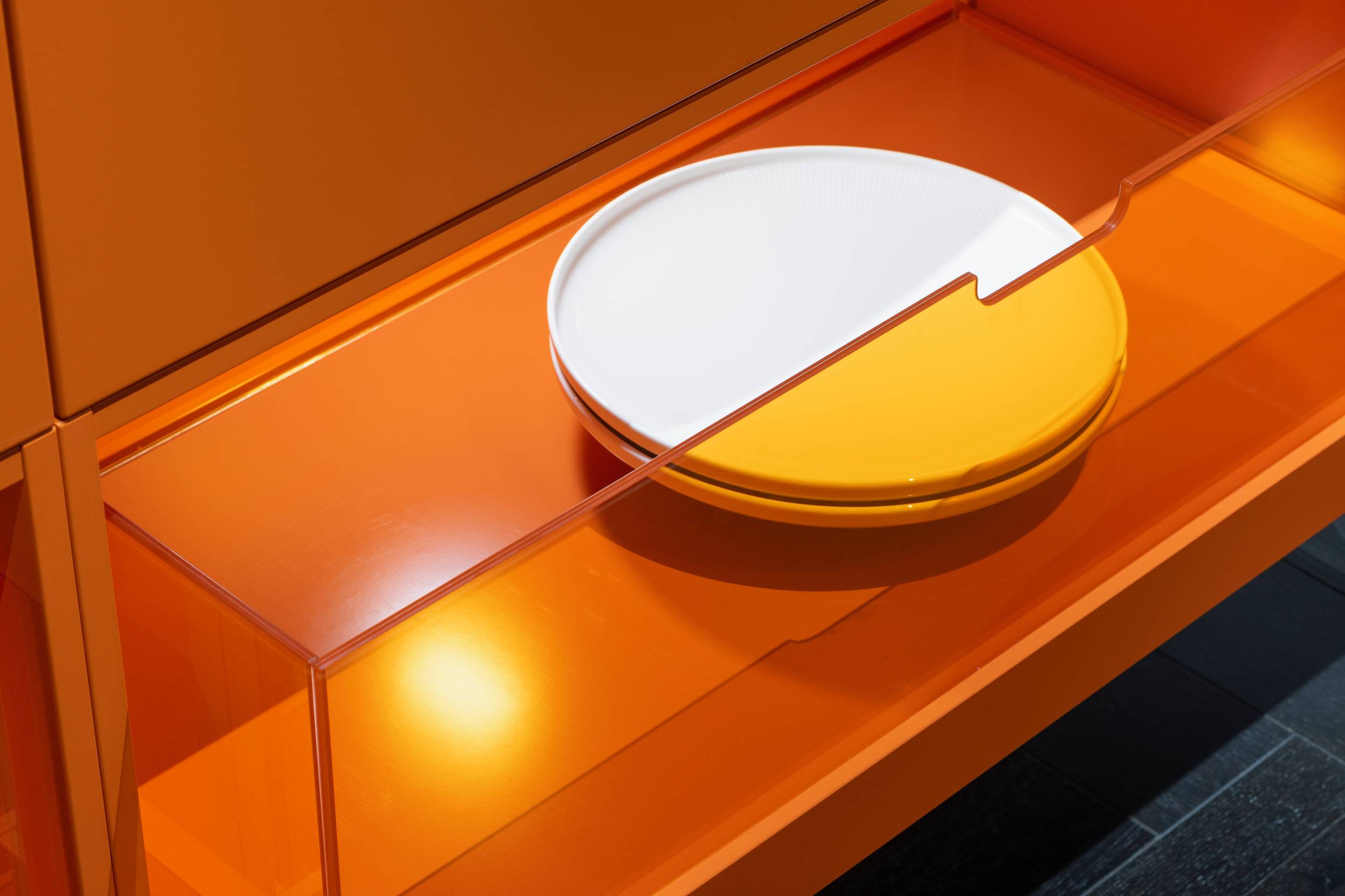 HÄCKER Systemat Betonküche mit Statement-Sideboard in orange - Detailansicht mit orangem Plexiglas als Schublade